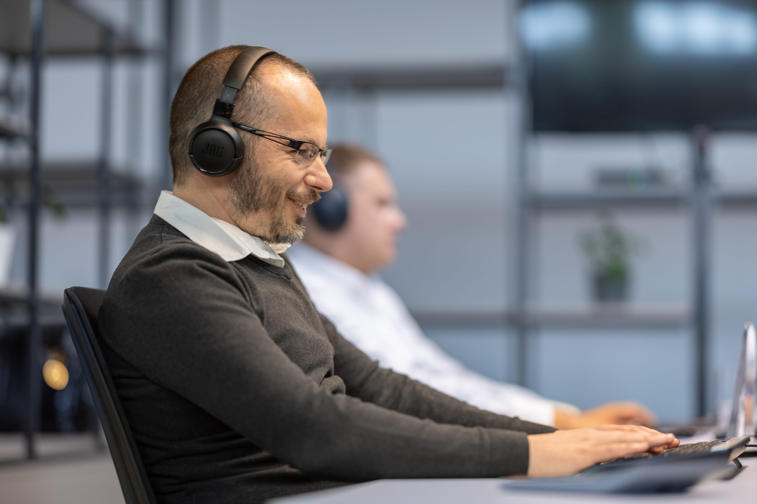 Ügyfélszolgálati munkatárs éppen ügyféllel beszél telefonon a Konverz irodájában
