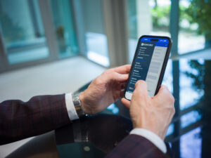 Mobiltelefonos online pénzváltást intéző férfi egy kávézóban